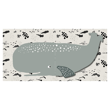 Baby cloth book spread showing a large grey whale with white spots on a cream background with ocean patterns.