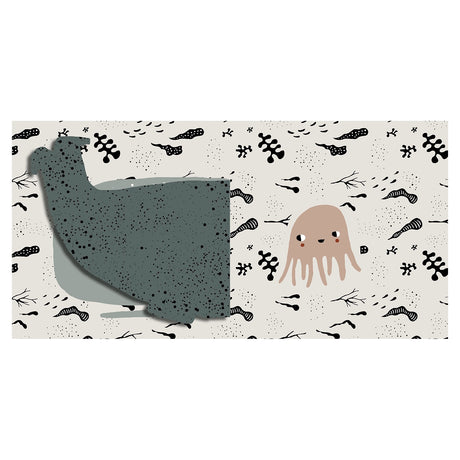 Baby cloth book spread showing a lifted whale flap revealing a small cute jellyfish on a cream ocean-patterned background.