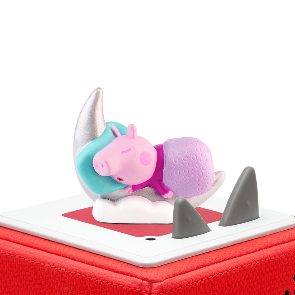 A playful Peppa Pig figurine sleeping on a silver crescent moon.