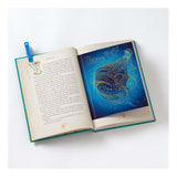 Open book with Peter Pan text and a gold-etched Tinker Bell illustration on a blue pop-up page.