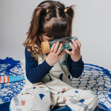 A young girl holding a sensory bottle up to her face to look through it.