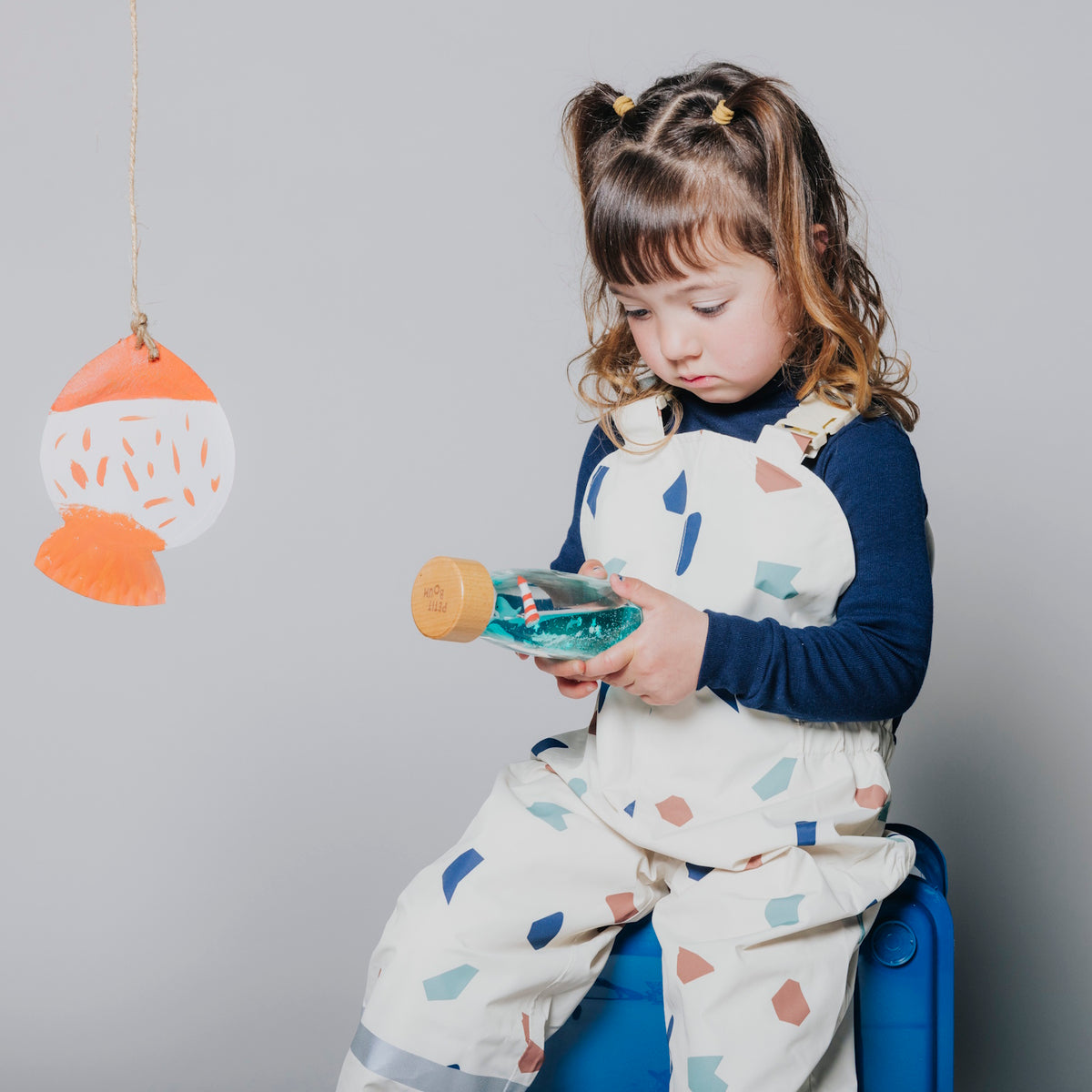 Young girl looking at a sensory bottle.