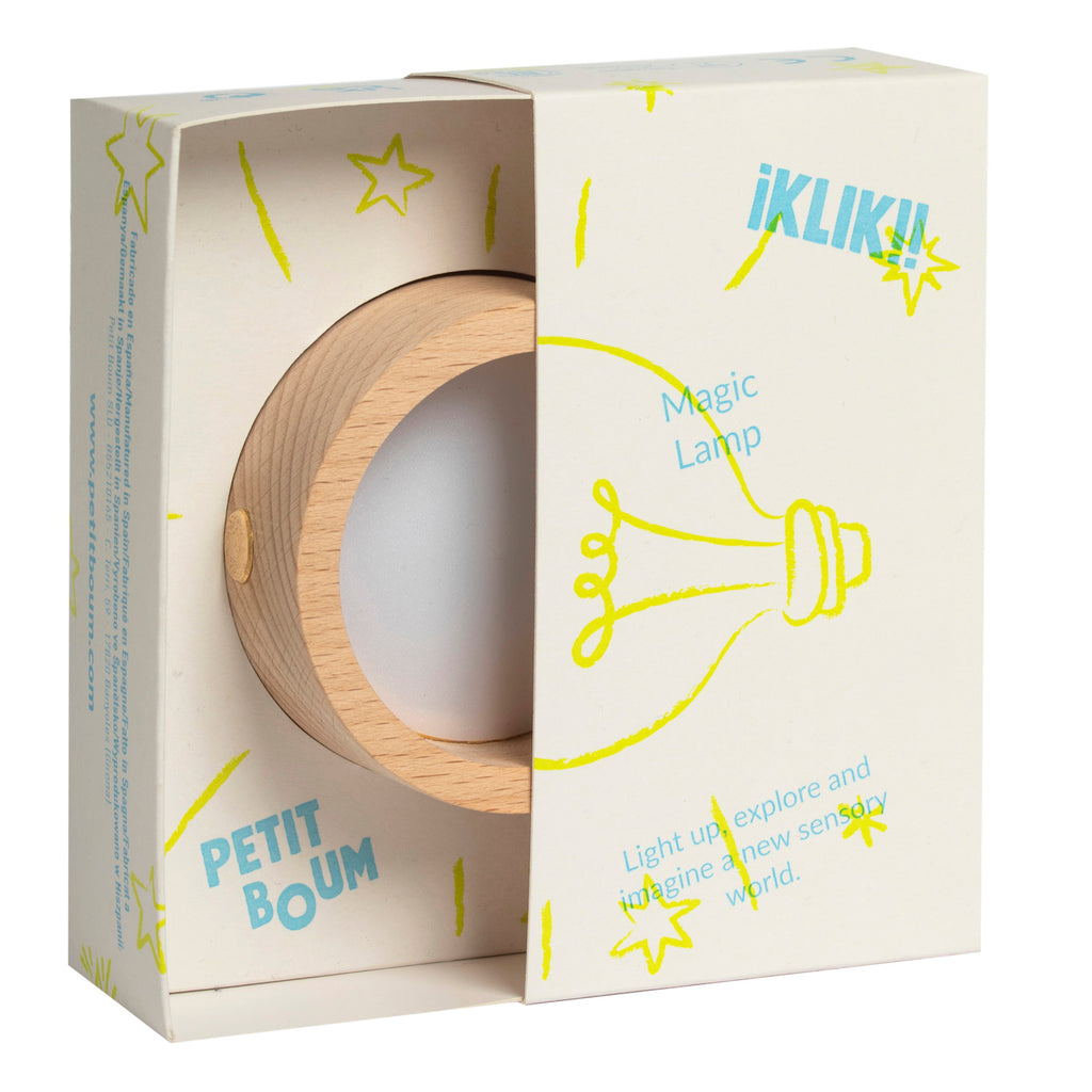 Wooden lamp in an open white box, featuring colorful doodles and text. The lamp is circular with a smooth finish, conveying a modern, playful tone.