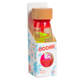 Wooden-capped sensory bottle in packaging. Clear with swirling neon liquid and small floating objects, labeled "OOOHH! Sensory bottle" for ages 3+.