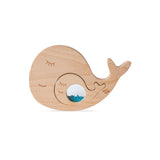 Smaller baby whale piece fitted into the larger wooden whale puzzle piece.
