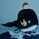 Toddler holding the whale sensory puzzle while wearing a large whale costume.