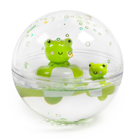 A clear sphere containing two smiling green frog toys floats in water, surrounded by air bubbles. The scene is playful and whimsical.