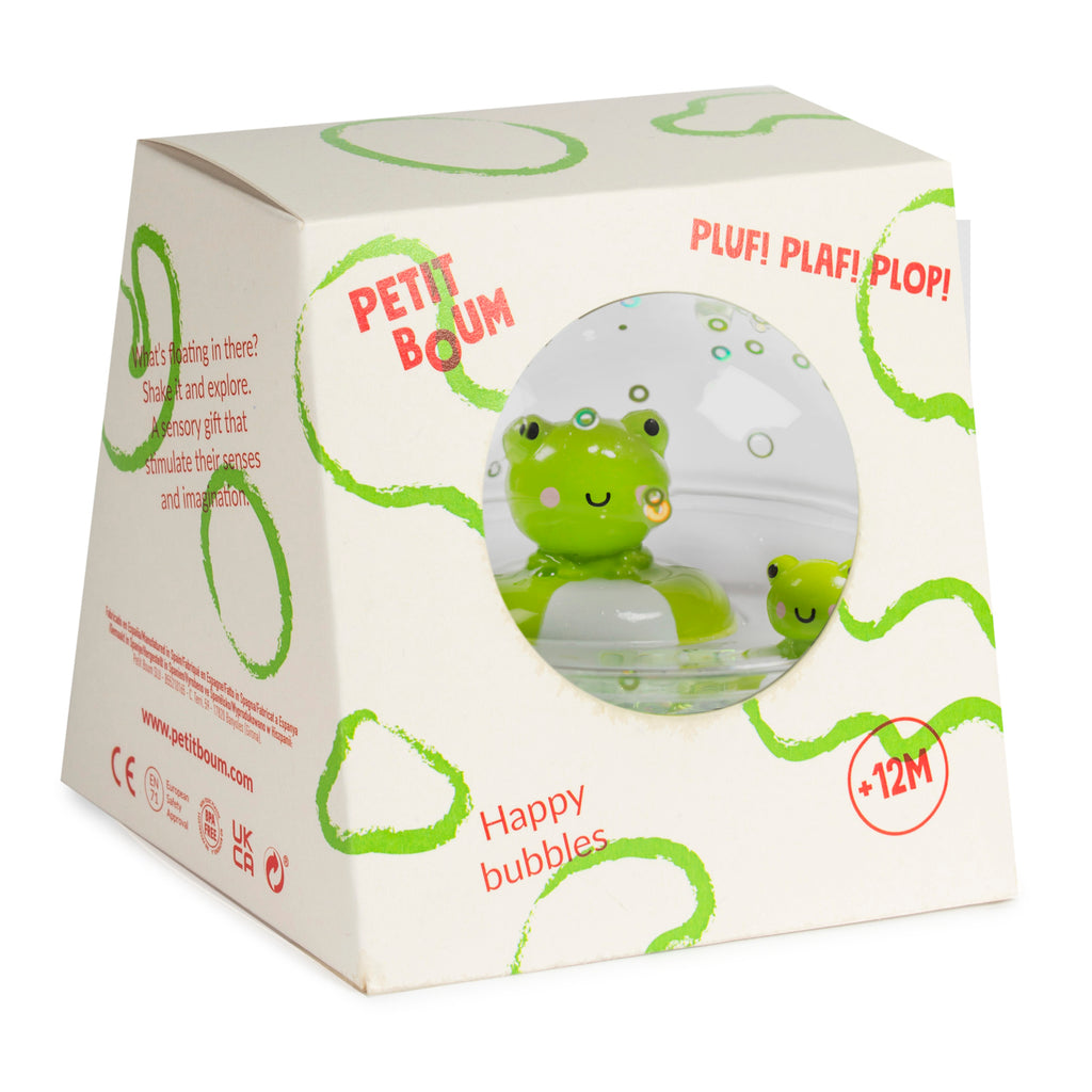 Packaging of a sensory toy with a green frog visible through a round window. The box features playful green circle designs and the text "Happy bubbles."