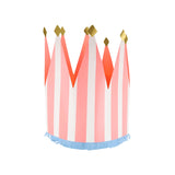 Pink and white striped paper party crown with gold glitter tips and a blue fringed base on a white background.