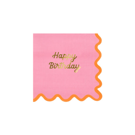 A square pink paper napkin with a wavy orange border and gold "Happy Birthday" text in the center.