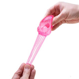 Pink glittery NeeDoh Jelly Squish fidget toy being stretched by two hands on a white background.