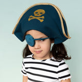 Young girl wearing a teal pirate hat with a gold skull print and a matching eye patch.