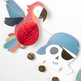 Close-up of pirate garland featuring a paper parrot with honeycomb belly, a pirate skull, and gold coins.