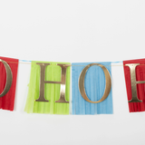 Close-up of pirate garland featuring gold foil letters set against colorful tissue paper fringe flags.