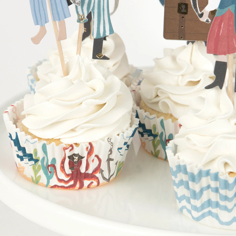 Cupcakes with swirled white frosting and oceanic pirate-themed liners featuring an octopus.