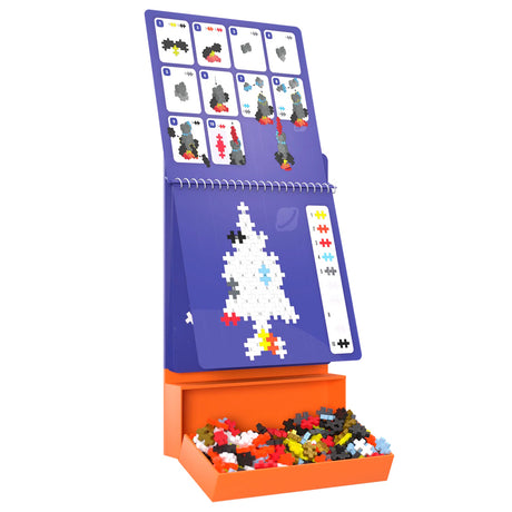Plus-Plus Activity Pad Space set featuring a rocket ship build guide, colorful puzzle pieces, and an orange storage tray.