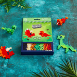 Plus-Plus Puzzle by Number Activity Pad with colorful 2D and 3D dinosaur builds and a 125-piece storage box.