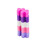 Two stacks of colorful, X-shaped blocks arranged vertically. Each stack has layers in pink, purple, white, and light red, creating a vibrant, playful aesthetic.