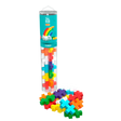 A clear tube labeled “Plus Plus Big Rainbow” holds colorful, cross-shaped pieces. Pieces spill out at the base, forming a vibrant, playful display.