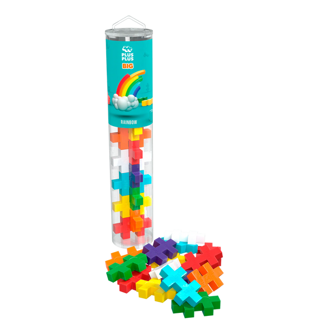 A clear tube labeled “Plus Plus Big Rainbow” holds colorful, cross-shaped pieces. Pieces spill out at the base, forming a vibrant, playful display.