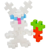 White rabbit figure made of Plus-Plus blocks holding an orange and green carrot against a plain white background.