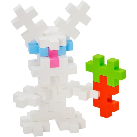 White rabbit figure made of Plus-Plus blocks holding an orange and green carrot against a plain white background.