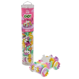 A colorful tube of Plus Plus GO! Candy Car interlocking blocks with a model car constructed beside it. The blocks are pastel pink, yellow, purple, and green.