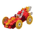 A toy race car made of interlocking blocks in red, yellow, and white, with large yellow wheels, displayed against a white background. The design is playful and imaginative.