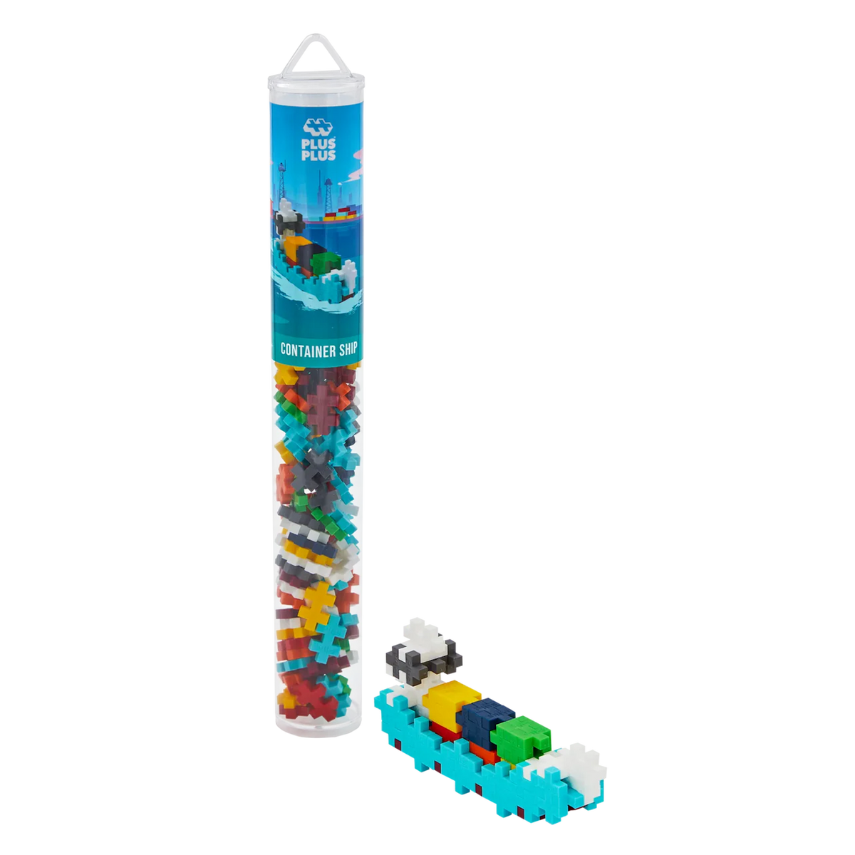 A Plus-Plus container ship toy set in a tall, clear tube showing colorful interlocking pieces. Assembled mini ship beside it. White background.