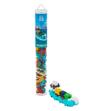 A Plus-Plus container ship toy set in a tall, clear tube showing colorful interlocking pieces. Assembled mini ship beside it. White background.