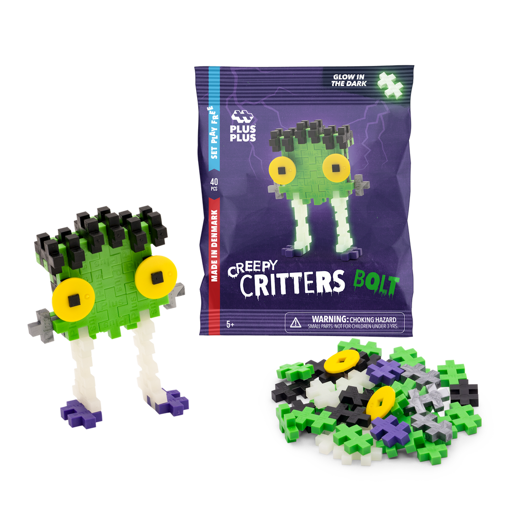 Toy packaging for "Plus-Plus Creepy Critters Bolt" featuring colorful interlocking pieces. A completed monster with green face, big yellow eyes, and white legs is assembled beside a pile of loose pieces. Glow-in-the-dark feature highlighted.