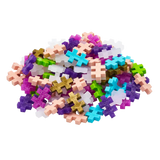 Pile of colorful interlocking puzzle pieces on a white background, featuring shades of pink, blue, purple, green, and gold. The scene feels playful and vibrant.