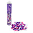 A clear tube labeled "Plus Plus Glitter" filled with pastel pink, purple, and white connecting pieces stands upright. A pile of pieces sits beside it.