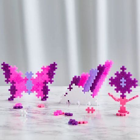 Colorful pixel art figures on a marble surface, including a butterfly, rabbit, and tree, in purple, pink, and white, creating a playful scene.