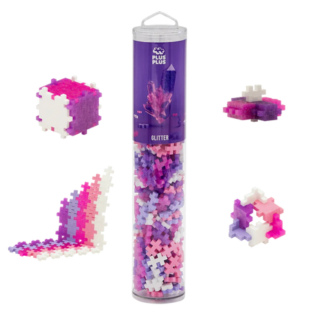 Tube of Plus-Plus glitter building blocks with pink, purple, and white pieces arranged in various shapes, set against a white background.