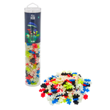 Tube of Plus-Plus Glow puzzle pieces with colorful interlocking pieces piled next to it. Packaging displays glowing mushrooms, creating a playful tone.