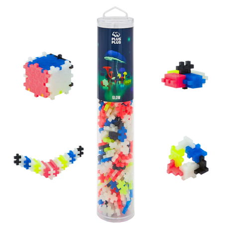 Transparent tube with colorful, interlocking plastic pieces labeled "Plus Plus Glow" against a white background. Shapes include a cube and a zigzag.