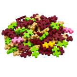 A pile of colorful interlocking plastic pieces shaped like simple geometric plus signs. Colors include green, red, pink, beige, and yellow on a white background.