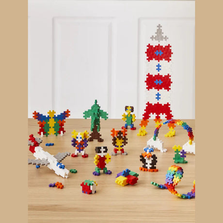 Various colorful 2D and 3D figures, including a rocket, plane, and animals, built with Plus-Plus construction blocks.