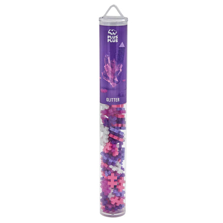 Plus-Plus Glitter tube with pink, purple, and white building pieces in a clear cylindrical container.