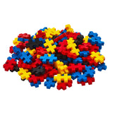 Pile of red, blue, yellow, and black Plus-Plus building blocks for kids on a white background.