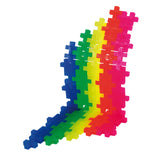 Plus-Plus building blocks in blue, green, yellow, red, and pink arranged in a colorful, interlocking rainbow wave.