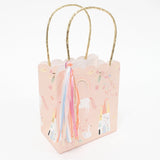 Pink unicorn-themed gift bag with gold handles and colorful ribbons.