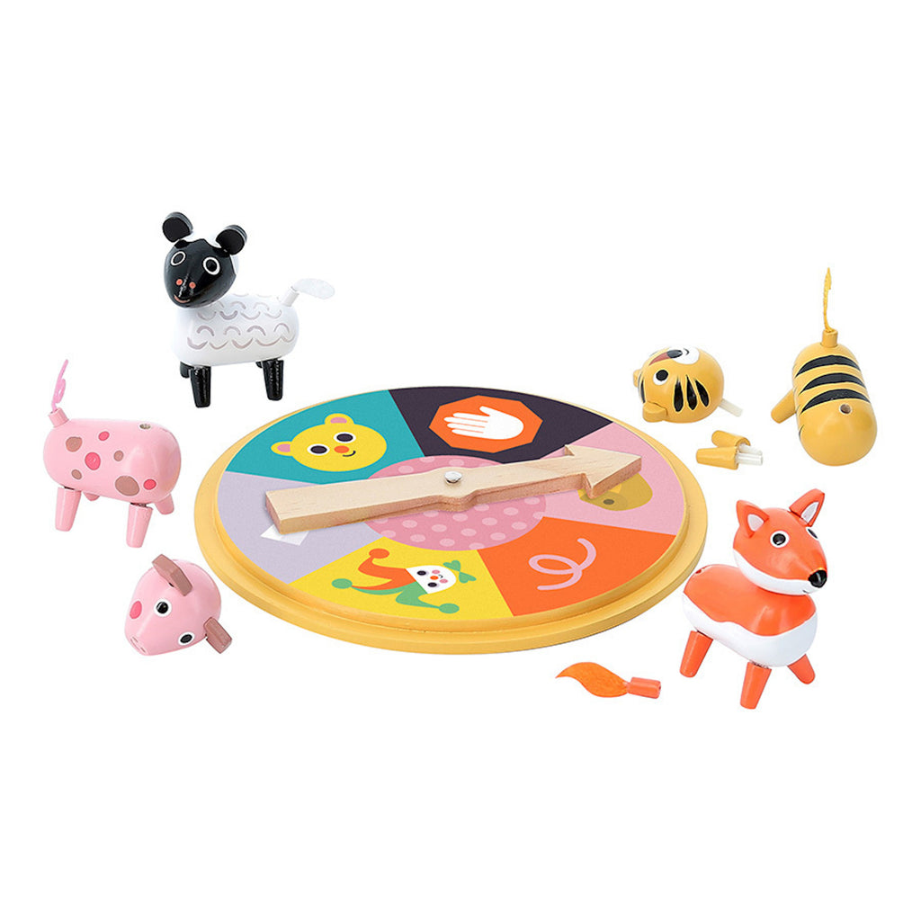 A colorful wooden spinner game with animal figures, including a sheep, pig, bee, and fox. The playful setting suggests a fun children's activity.