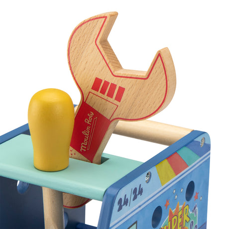 Close-up of a wooden toy wrench and hammer stored in a colorful toy activity truck by Moulin Roty.