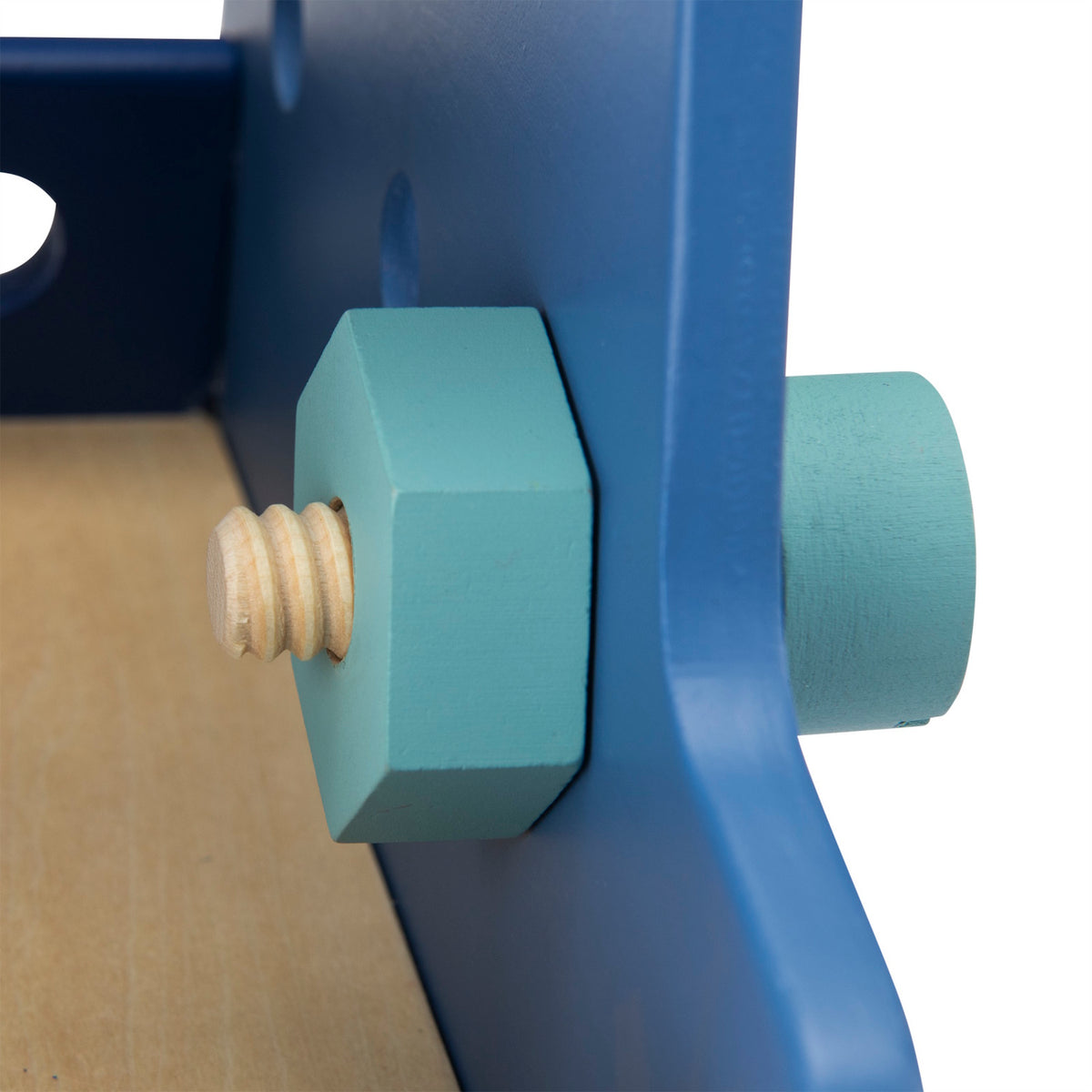 Close-up of a teal wooden toy nut and bolt attached to the blue side of a toy handyman activity truck.