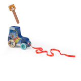 Wooden pull-along roller skate toy with a red ribbon and a separate cat-head peg against a white background.
