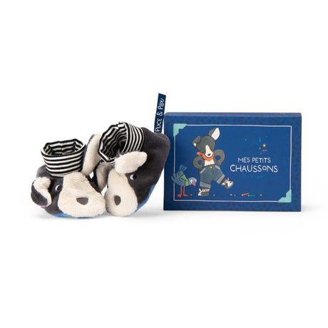 Plush Puce and Pilou dog baby slippers next to their blue gift box.