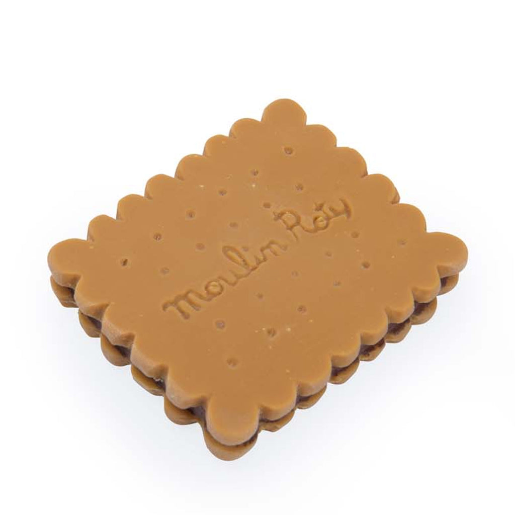 A rectangular, toy cookie made of rubber, mimicking a sandwich biscuit with scalloped edges and embossed with "Moulin Roty" on a white background.