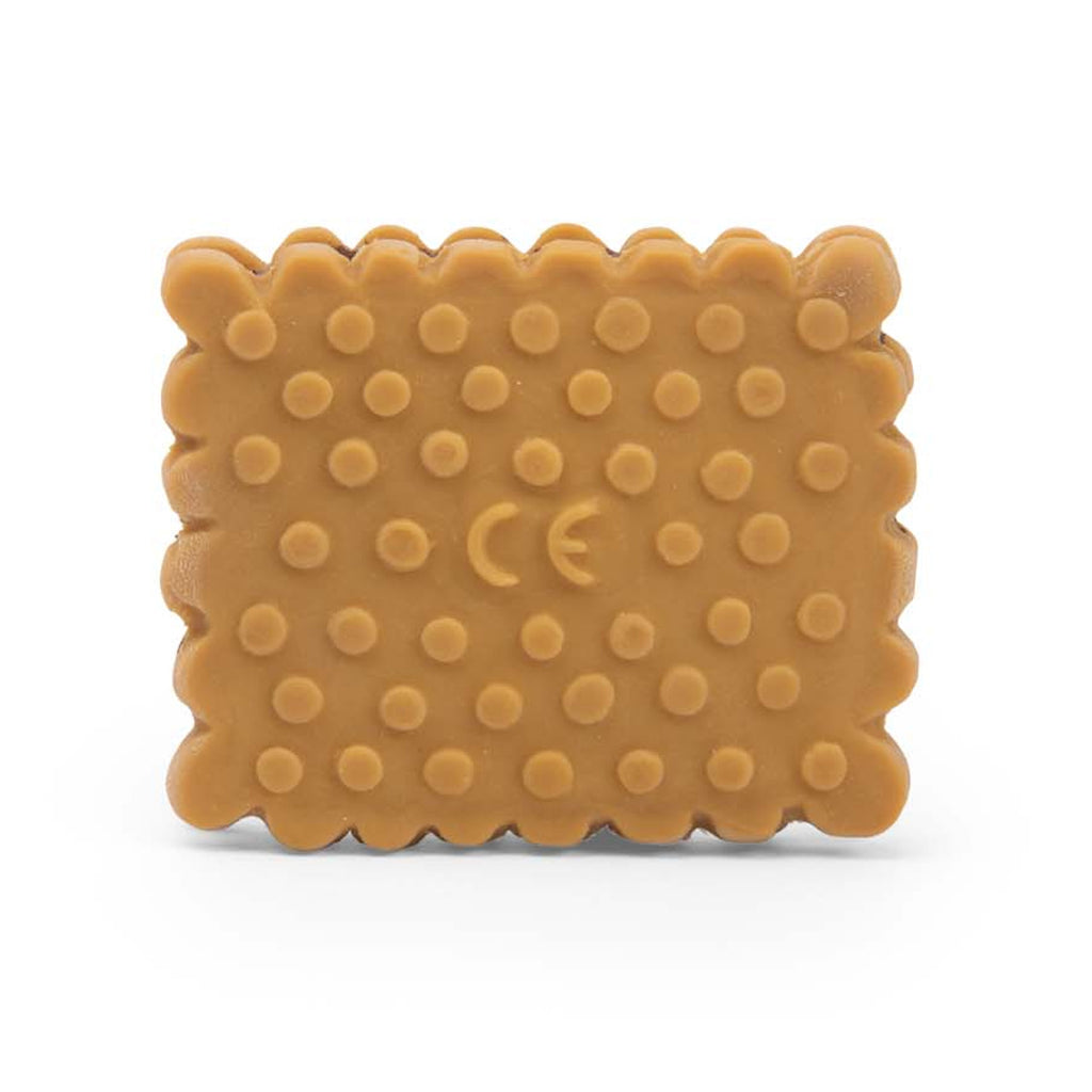 A rectangular, toy cookie made of rubber, mimicking a sandwich biscuit with scalloped edges and embossed with "Moulin Roty" on a white background.